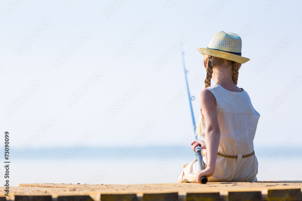 Girl in a dress and a hat with a fishing rod Girl in a dress and a hat with a fishing rod
