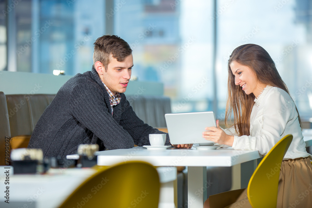 Flirting couple in cafe using digital tablet, selective focus Flirting couple in cafe using digital tablet, selective focus