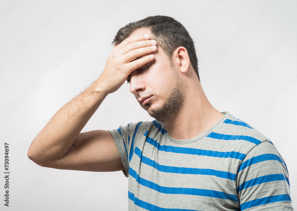 Depressed young man holding head in hands Depressed young man holding head in hands