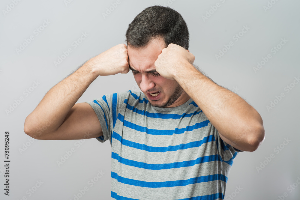 Depressed young man holding head in hands Depressed young man holding head in hands