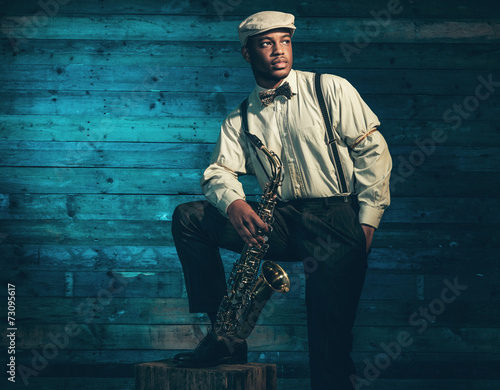 Photography African american jazz musician with saxophone in front of old wo