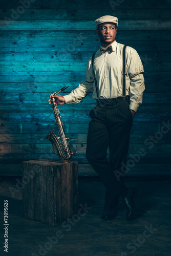 Photography African american jazz musician with saxophone in front of old wo