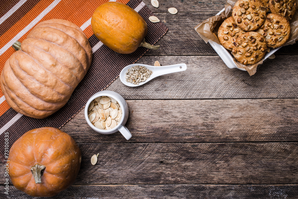 Pumpkins, seeds and cookies with nuts on wood in Rustic style Pumpkins, seeds and cookies with nuts on wood in Rustic style