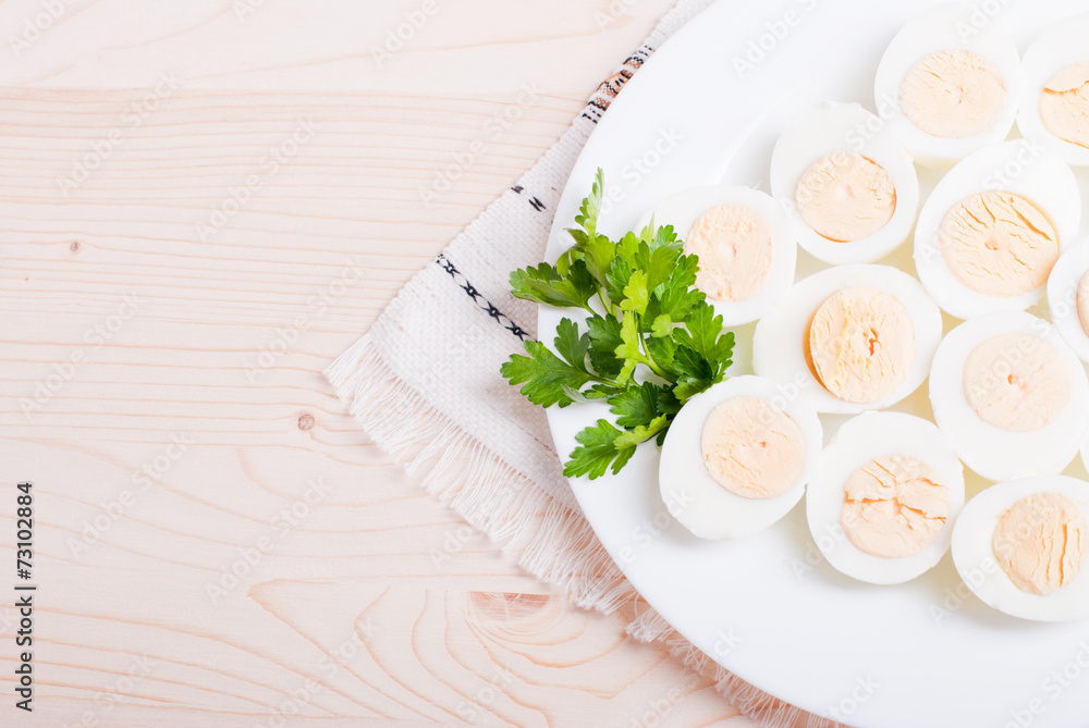 boiled eggs cut in half on a white plate with parsley on a napki boiled eggs cut in half on a white plate with parsley on a napki