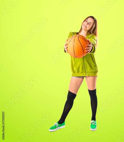 Pretty young girl wearing urban style with basketball