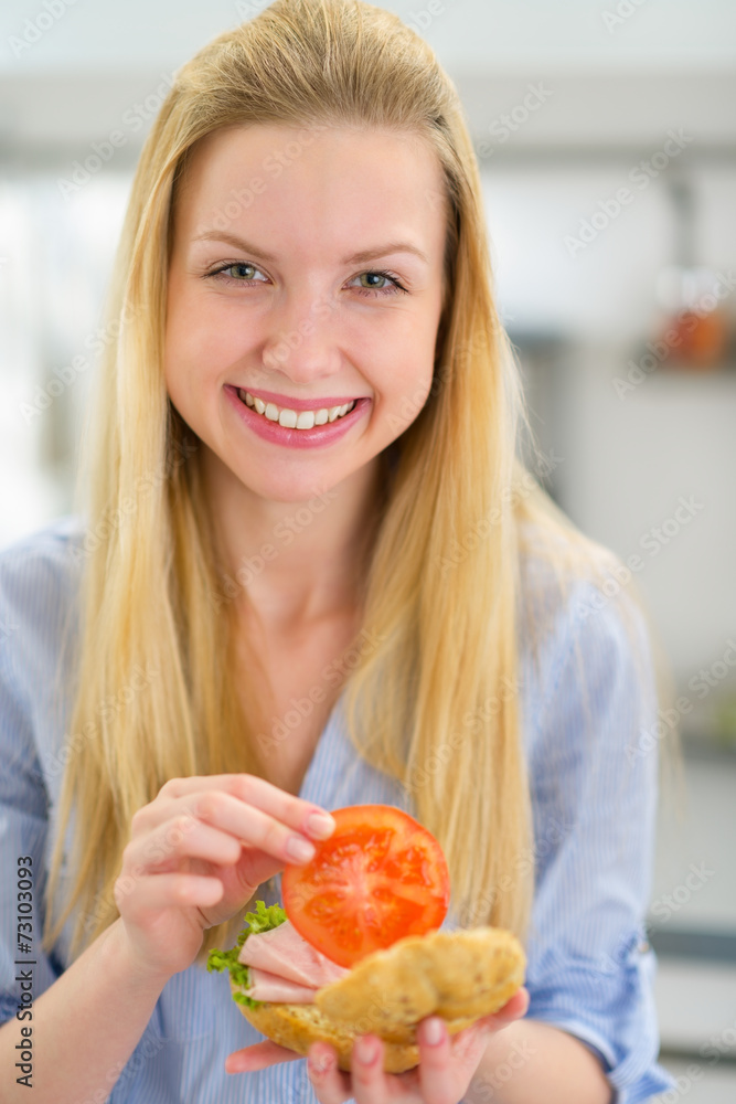 Smiling young woman making sandwich Smiling young woman making sandwich