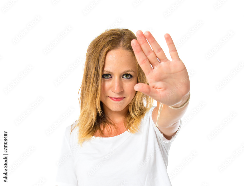 Girl making stop sign over white background Girl making stop sign over white background