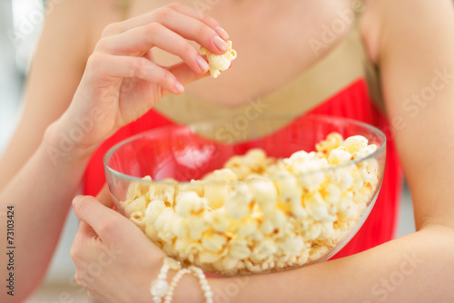 Closeup on young woman eating popcorn