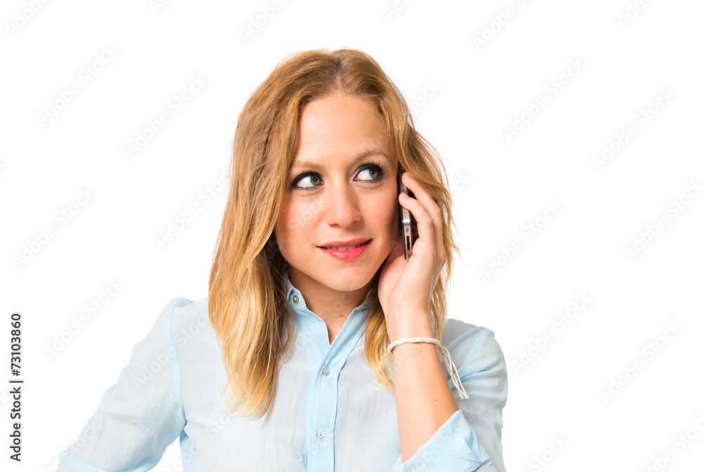 Blonde girl talking to mobile over white background