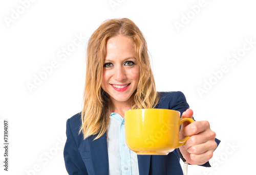 Blonde girl holding a cup of coffee over white background
