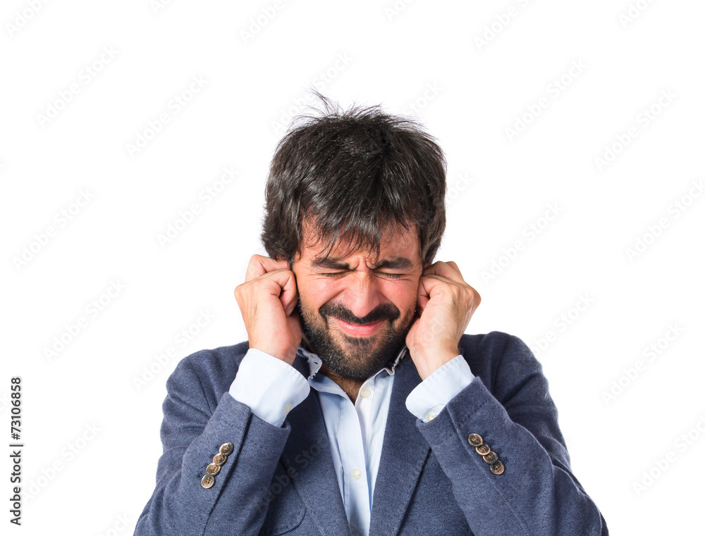 Man covering his ears over white background Man covering his ears over white background