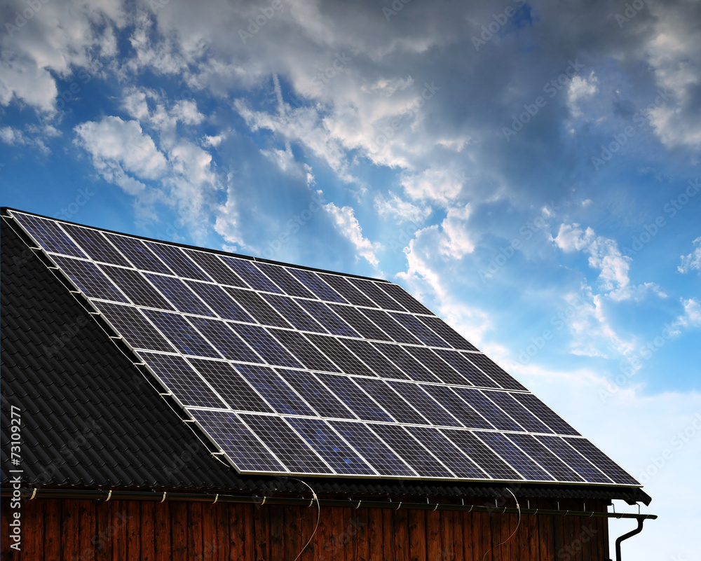 Naklejka premium Solar panel on the roof of the house at sunset