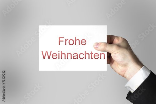 Hand hält weiße Karte Frohe Weihnachten