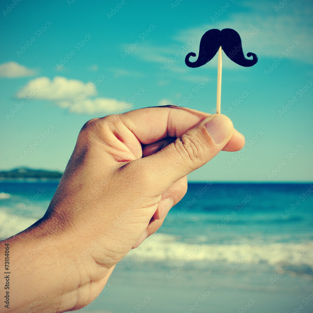 man hand with a fake moustache on the beach, with a filter effec - obrazy, fototapety, plakaty 
