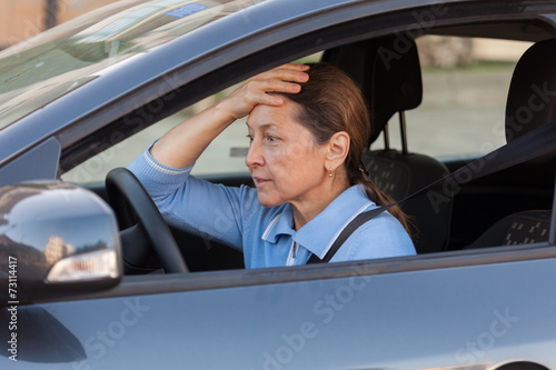 frightened mature woman in car.