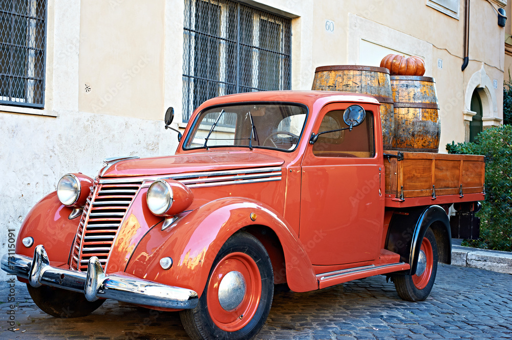 Vintage red van with old wooden barrels of wine