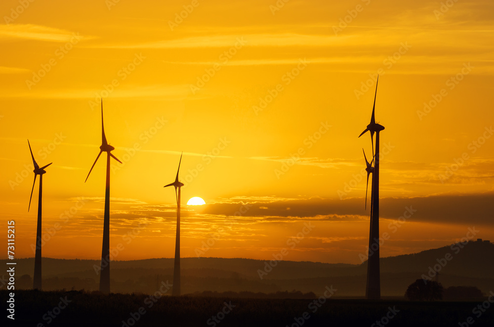 Fototapeta premium Windwheels and a beautiful sunset seen in rural Germany