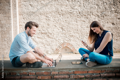 young couple using technology multitasking smarpthone tablet and photo