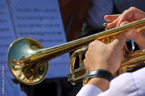 Musician playing trumpet in street orchestra