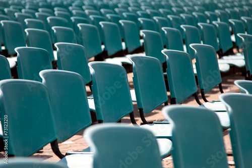 Rows of empty blue chairs for audience