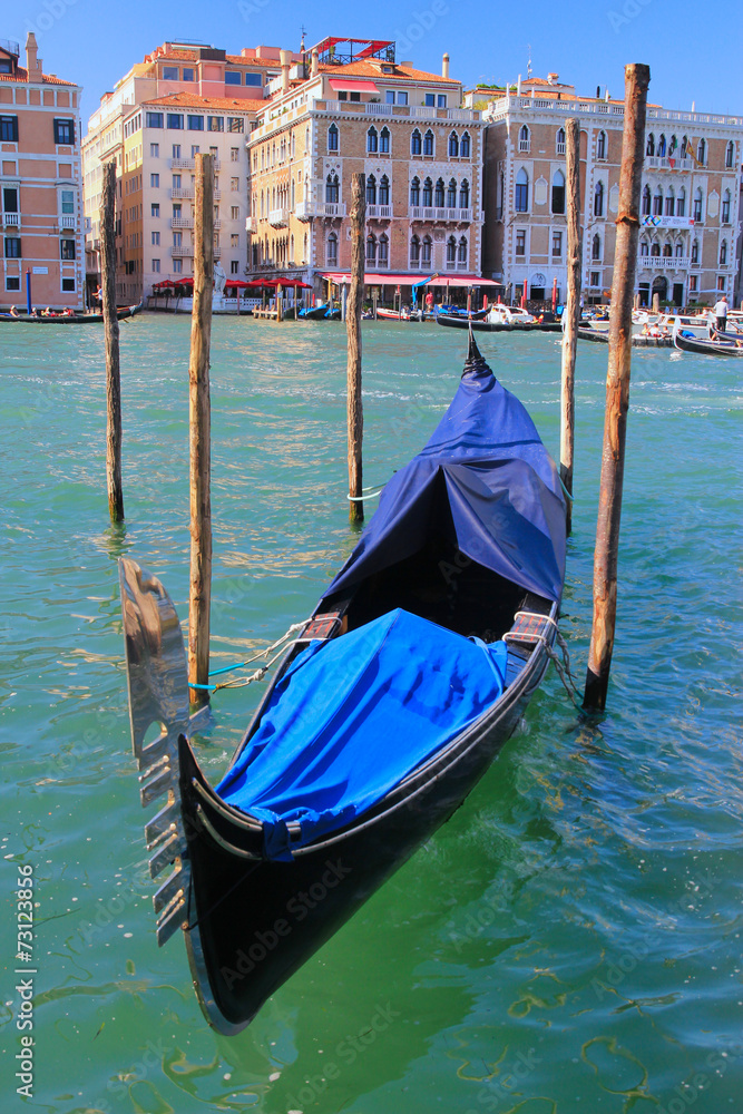 Venice, gondola in the foreground anchored to the shore.