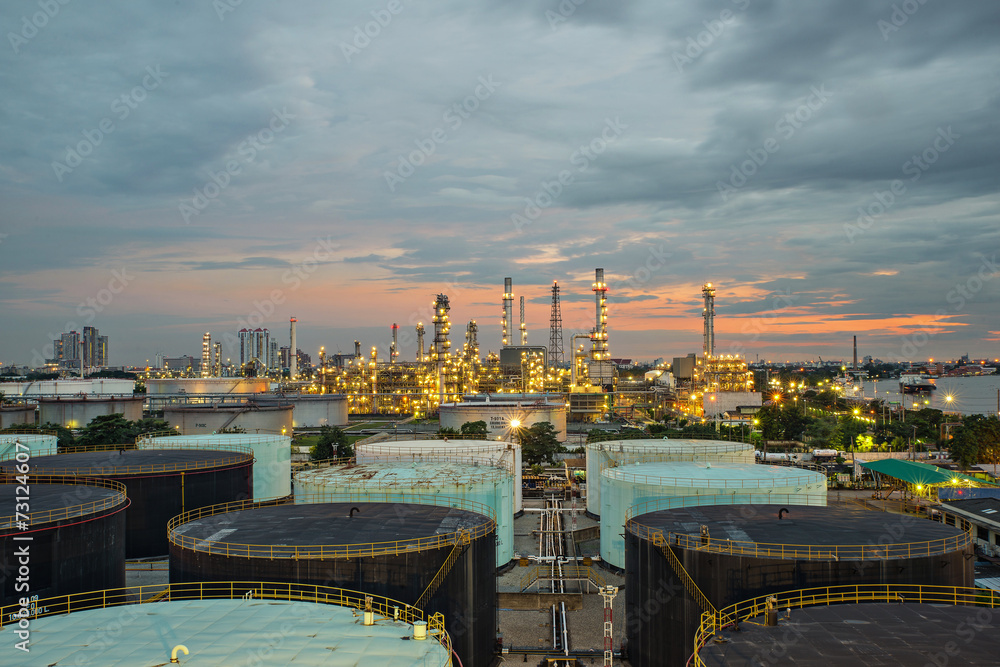 Naklejka premium Oil refinery and storage tank at twilight