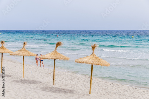 Straw umbrellas on sand beach.