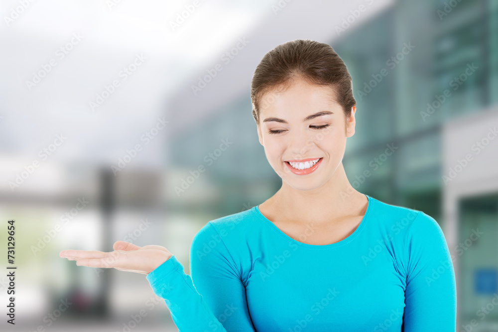 Happy , excited young woman presenting copy space Happy , excited young woman presenting copy space