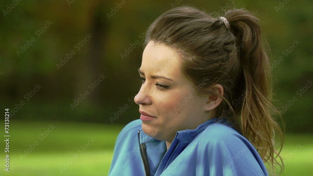 Woman resting after jogging in the park, slow motion, steadycam Woman resting after jogging in the park, slow motion, steadycam