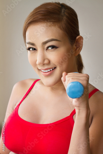 smiling woman with dumbbell concept of working out, fitness, he
