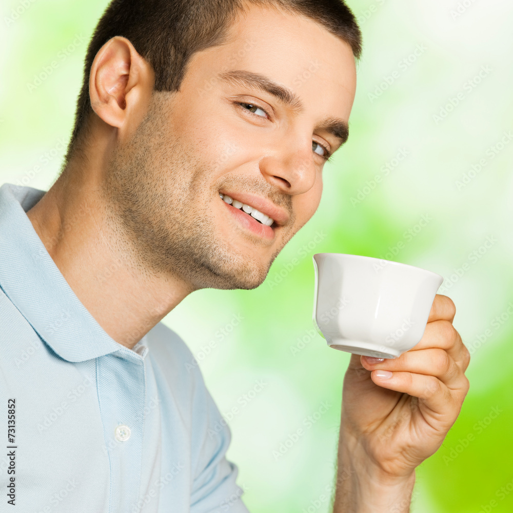 Portrait of young happy smiling man drinking coffee, outdoors Portrait of young happy smiling man drinking coffee, outdoors