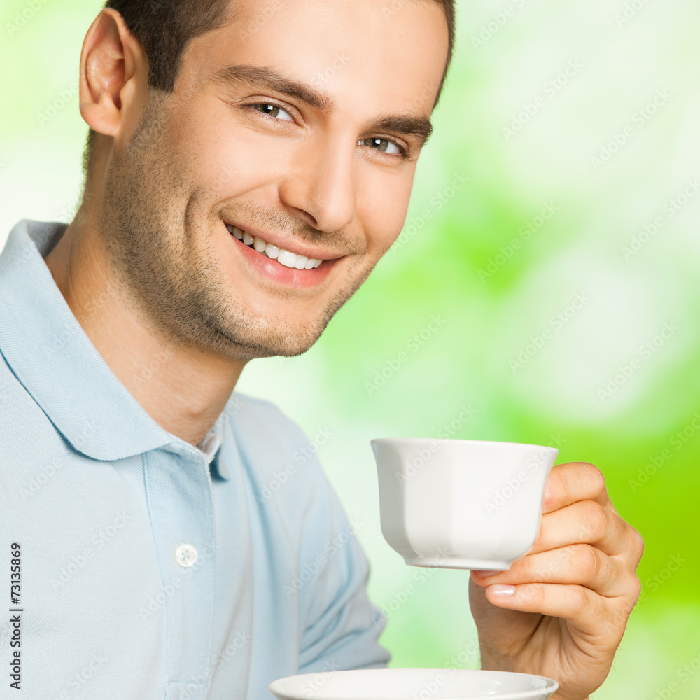 Portrait of young happy smiling man drinking coffee, outdoors Portrait of young happy smiling man drinking coffee, outdoors