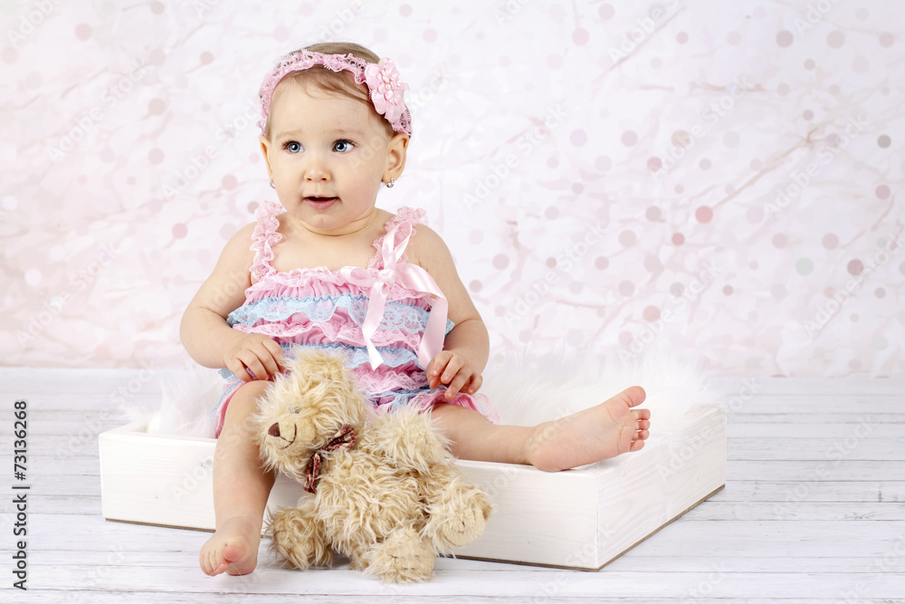 Stunning little baby girl with teddy bear