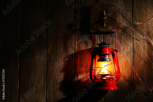 Lantern hanging on hook on wooden wall