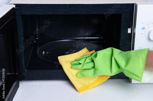 Cleaning microwave oven in kitchen close-up