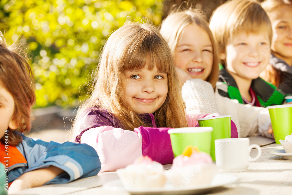 Fototapeta premium Happy children with tea cups sitting outside