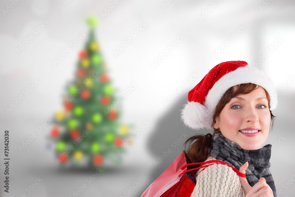 Composite image of smiling woman wearing santa hat