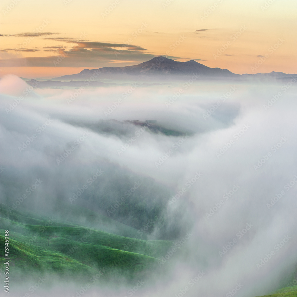Obraz premium Top of the mountain surrounded by mists