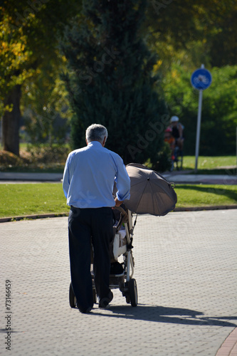 abuelo paseando con un carrito de niño