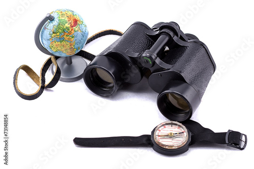 large binoculars, globe and compass on a white background