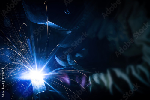 Employee welding structures with sparks