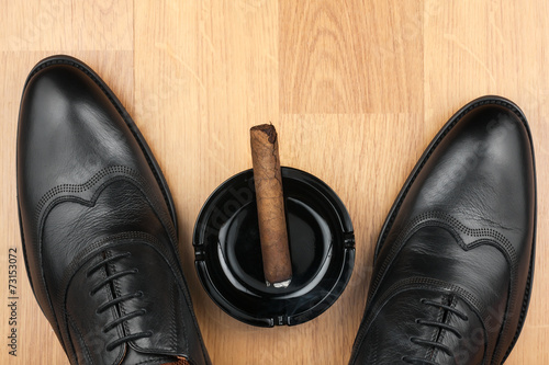 Classic men s shoes  ashtray and  fuming cigar on the wooden flo