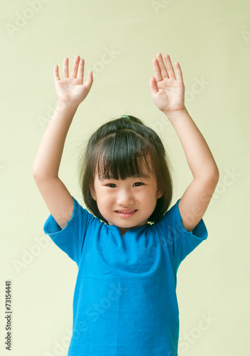 Excited asia little child raising two hand up