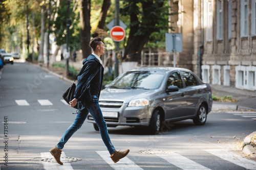 Young man cross the street Fototapet