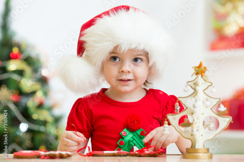 child girl in Santa hat mak...