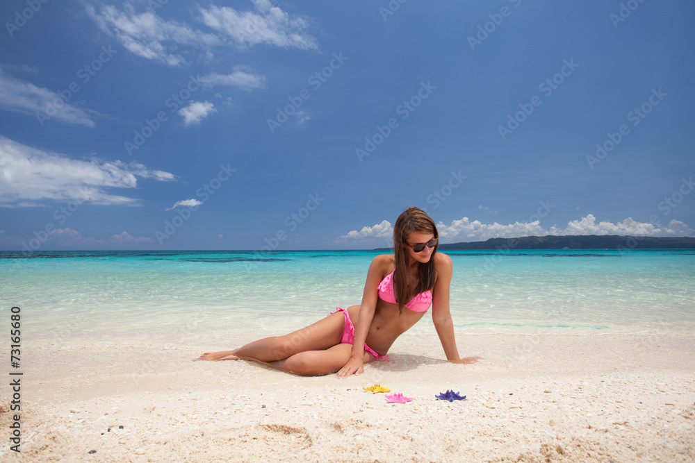 Beautiful girl sitting on the beach
