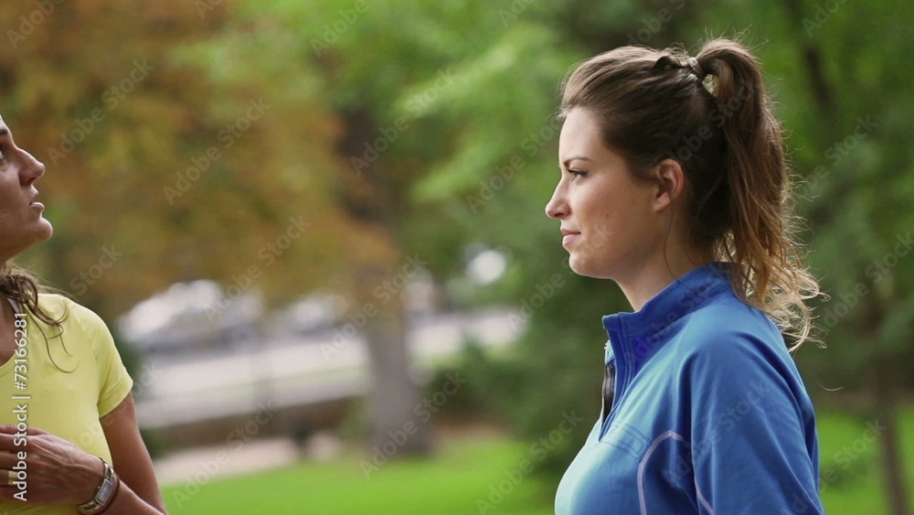 Sporty women chatting in the park, slow motion shot, steadycam Sporty women chatting in the park, slow motion shot, steadycam