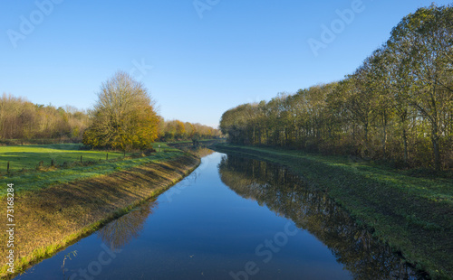 Canal in a rural landscape under a clear sky at fall