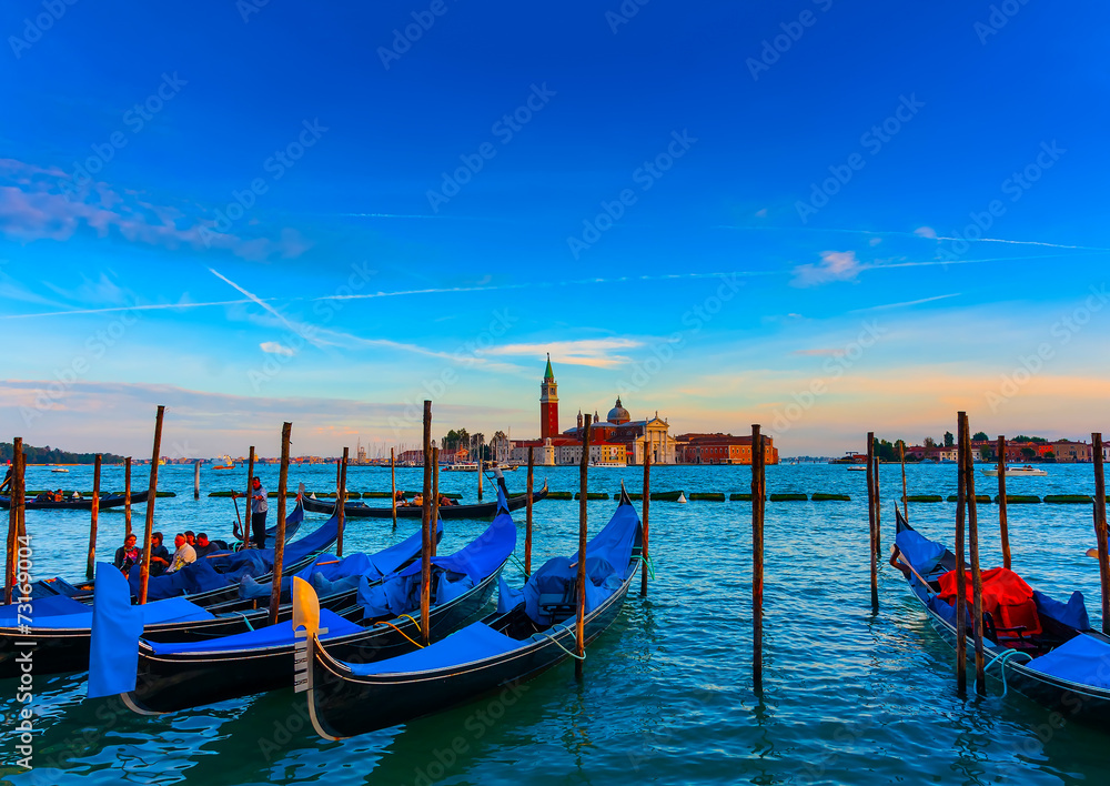 several Gondolas docked at Venice Italy. Sunset time