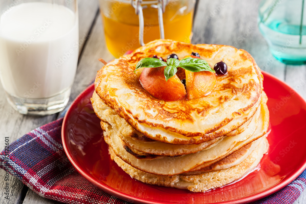 Pancakes with honey, fruit and glass of milk Pancakes with honey, fruit and glass of milk